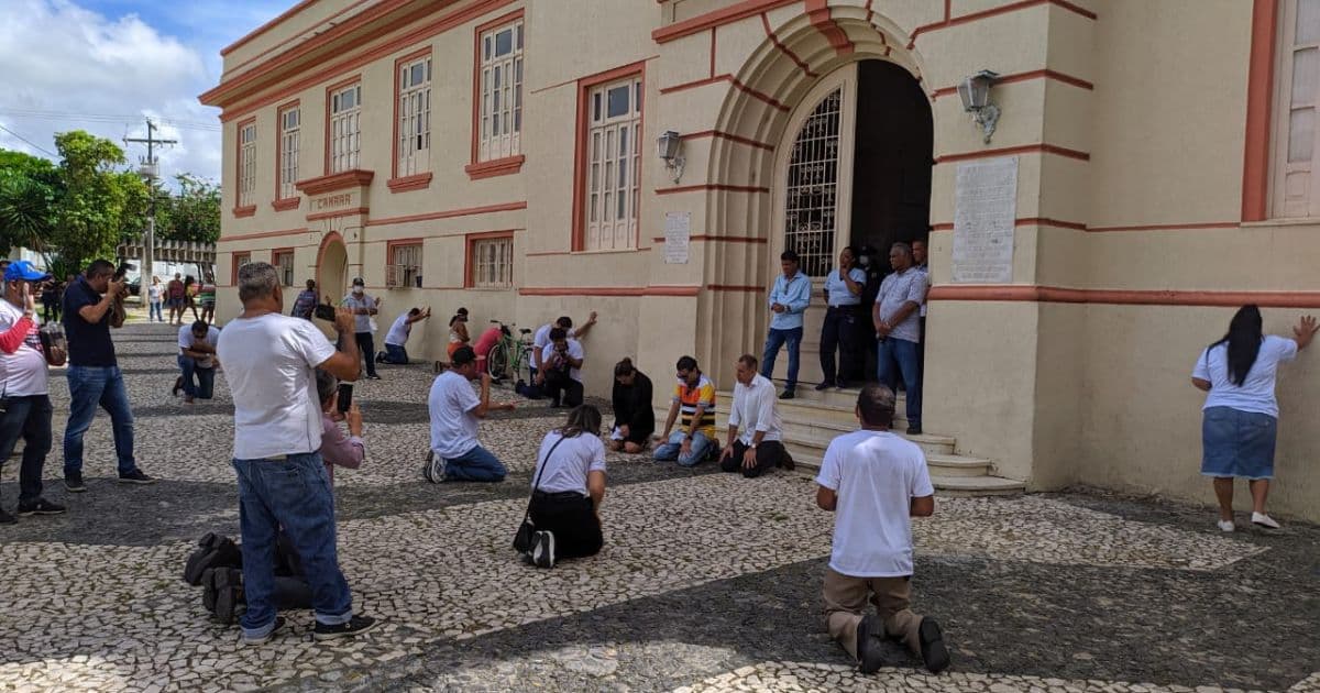 Prefeito de Alagoinhas se ajoelha em oração contra o coronavírus em frente à prefeitura
