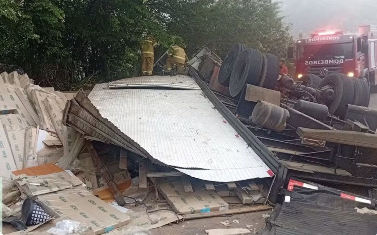 Motorista morre após caminhão tombar e espalhar carga de móveis na BR-101, em Itabela